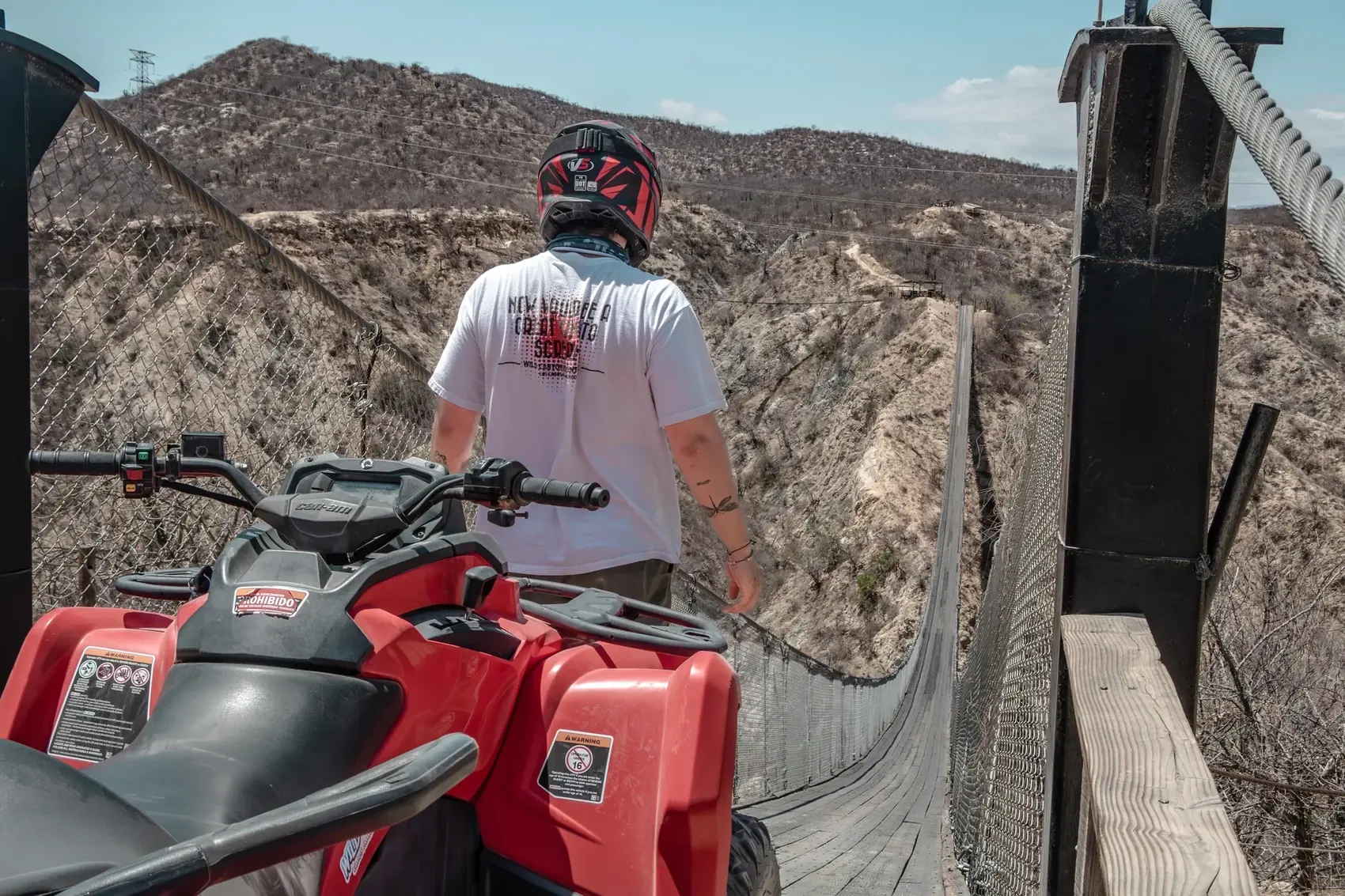 Piloto en ATV cruzando el puente colgante de Wild Canyon