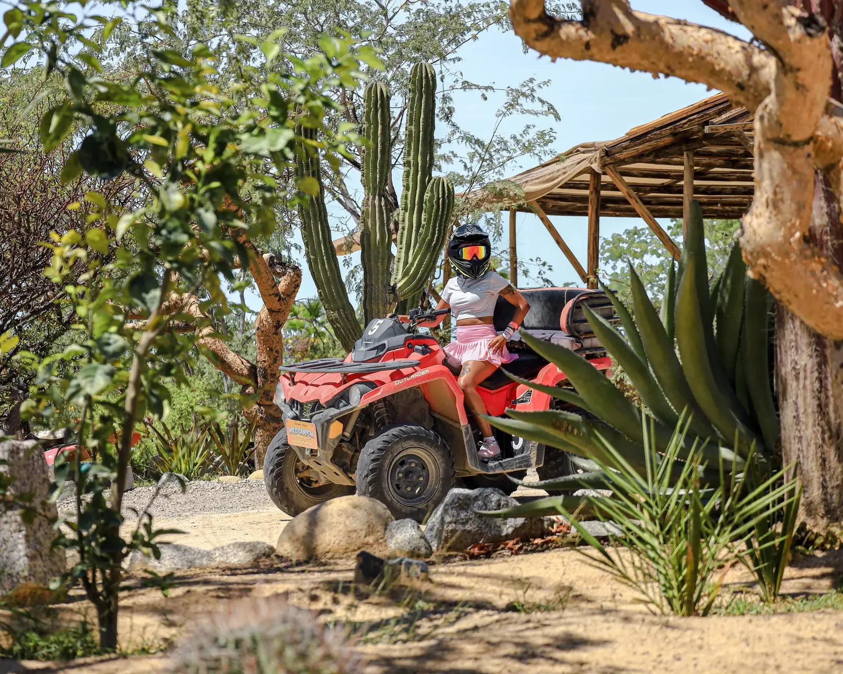 Mujer en ATV Outlander en el jardin de cactus