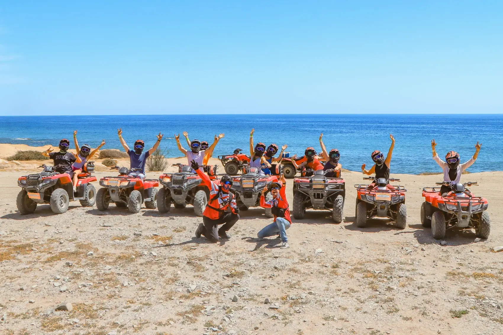 Grupo celebrando arriba de sus ATV frente al mar