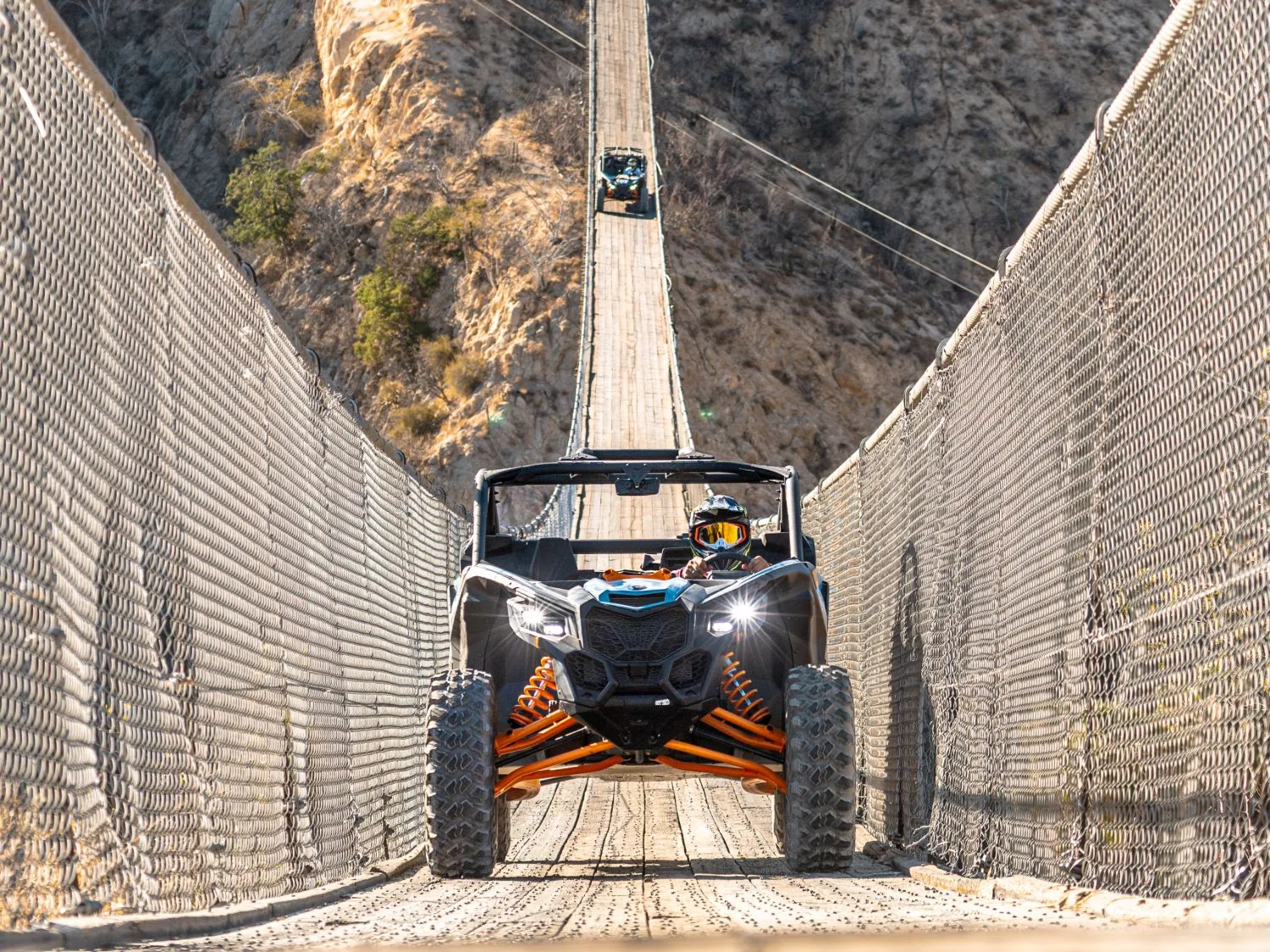 Can-Am Maverick cruzando de frente el puente colgante del cañón en Wild Canyon, con otro UTV al fondo