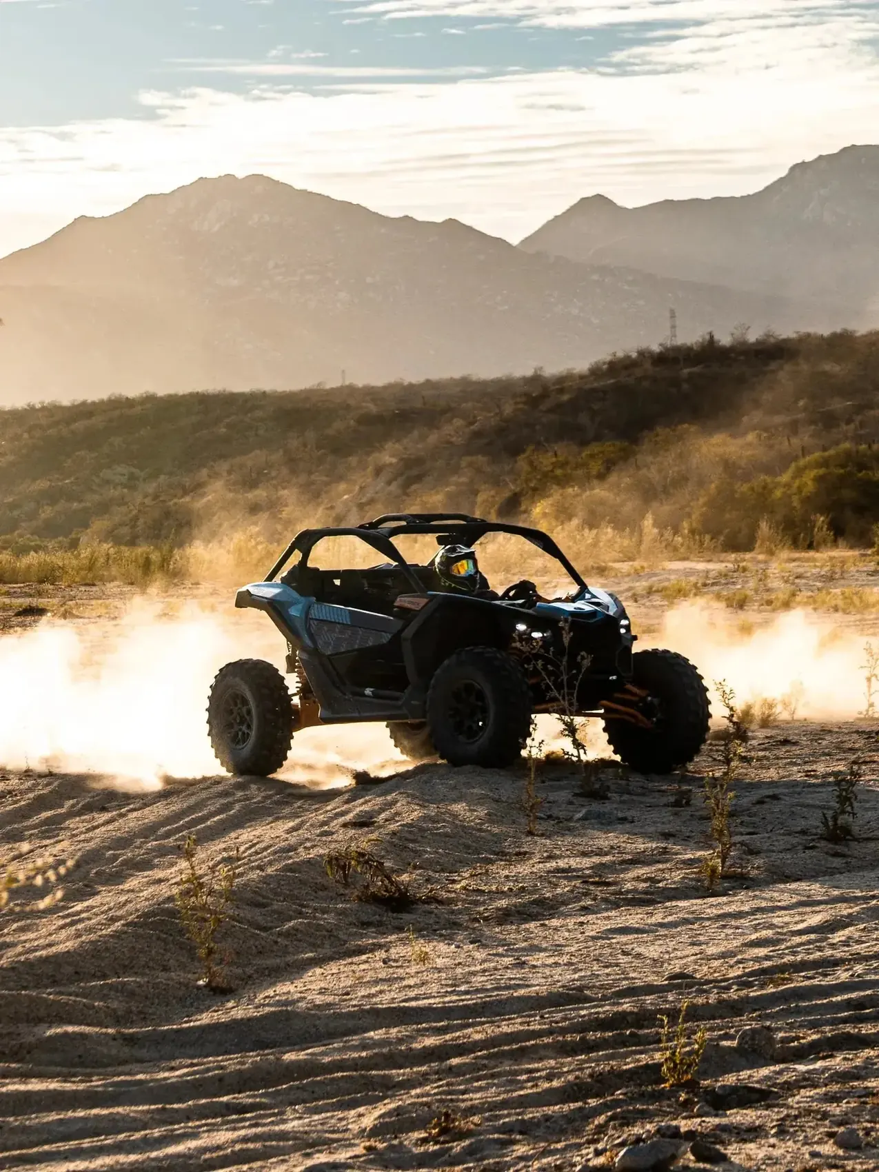 Can-Am Maverick UTV levantando polvo dorado al atardecer