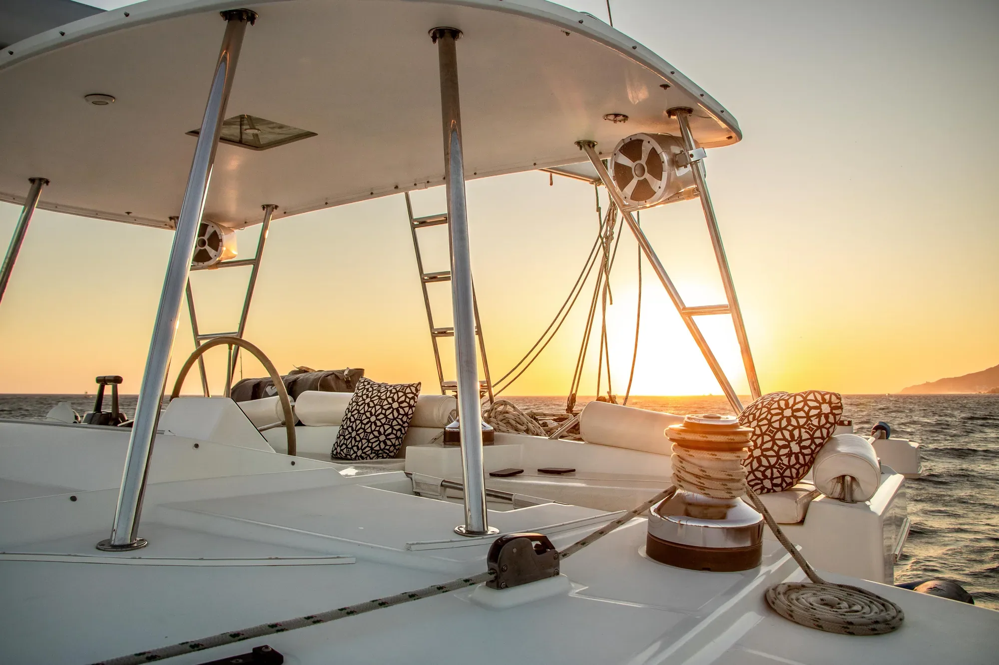 Cubierta del catamarán Satori al atardecer con luz cálida sobre el mar