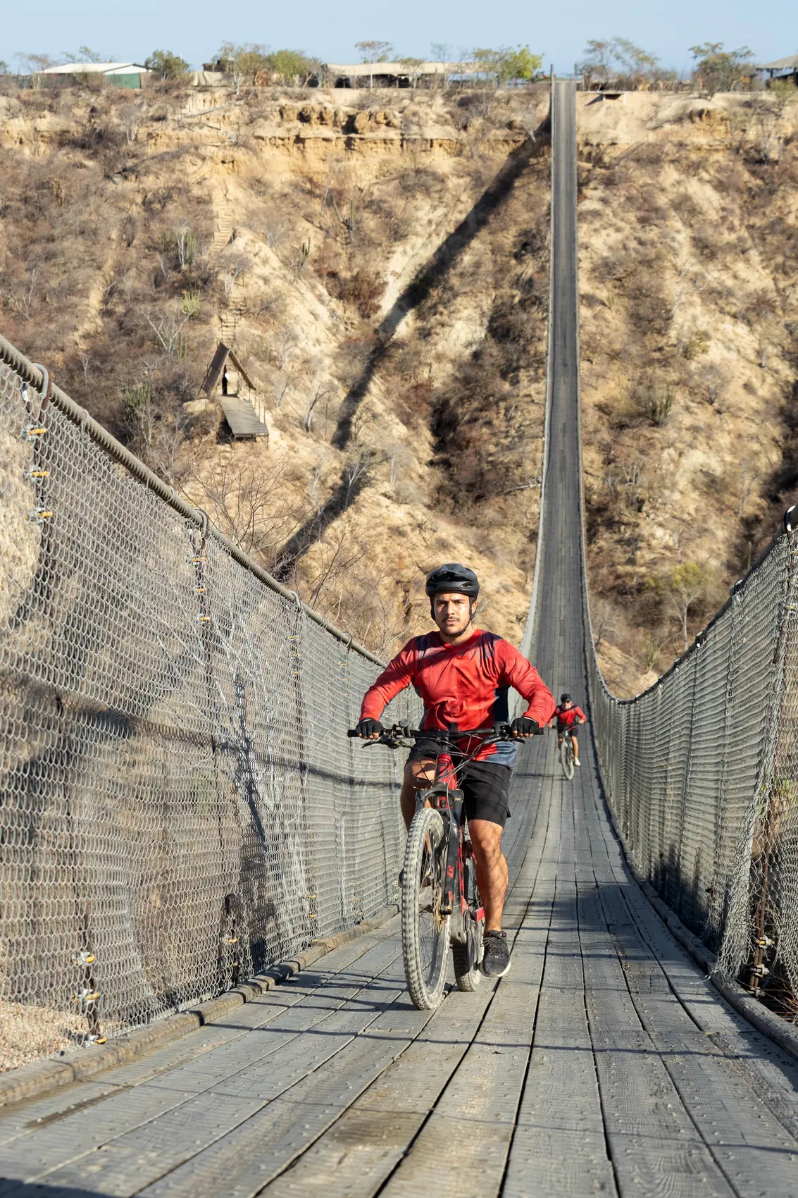 Rider acercandose a la camara sobre el largo puente colgante