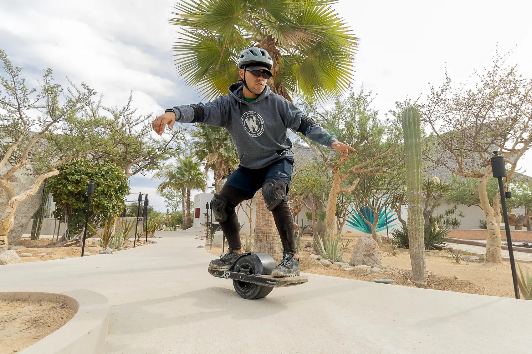 Persona en one-wheel por el sendero del parque
