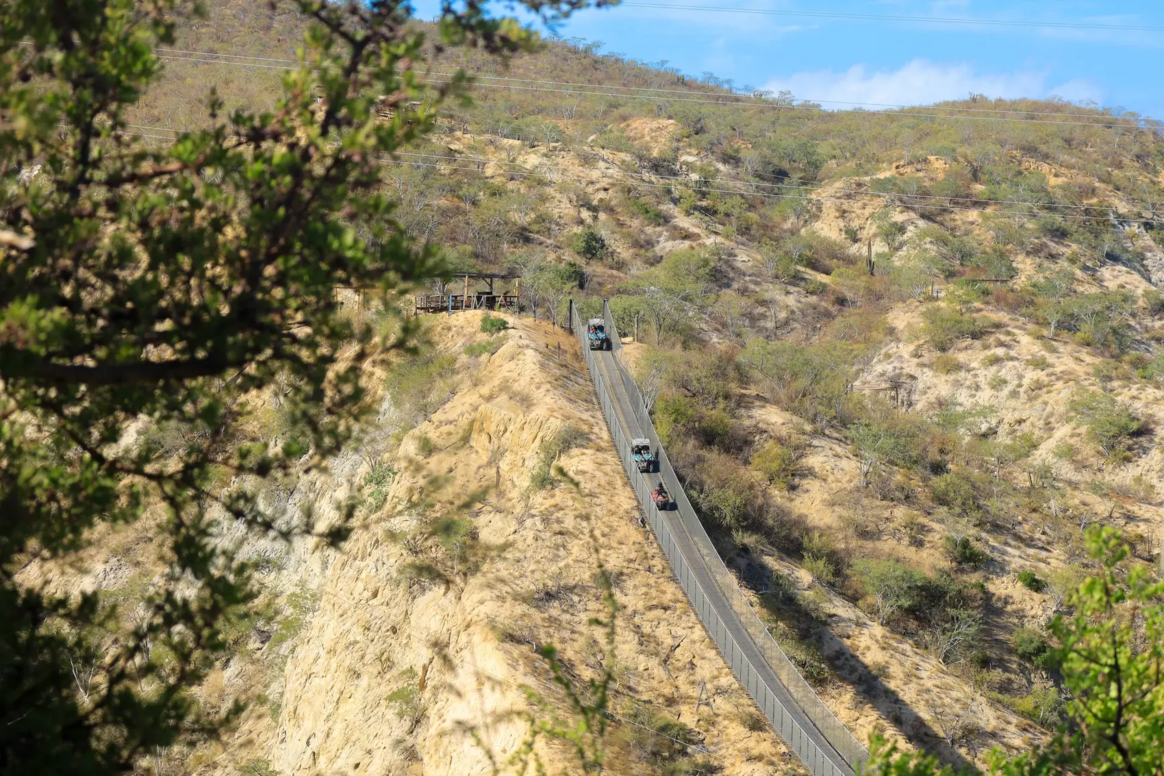 Convoy de UTV y ATV cruzando el puente colgante