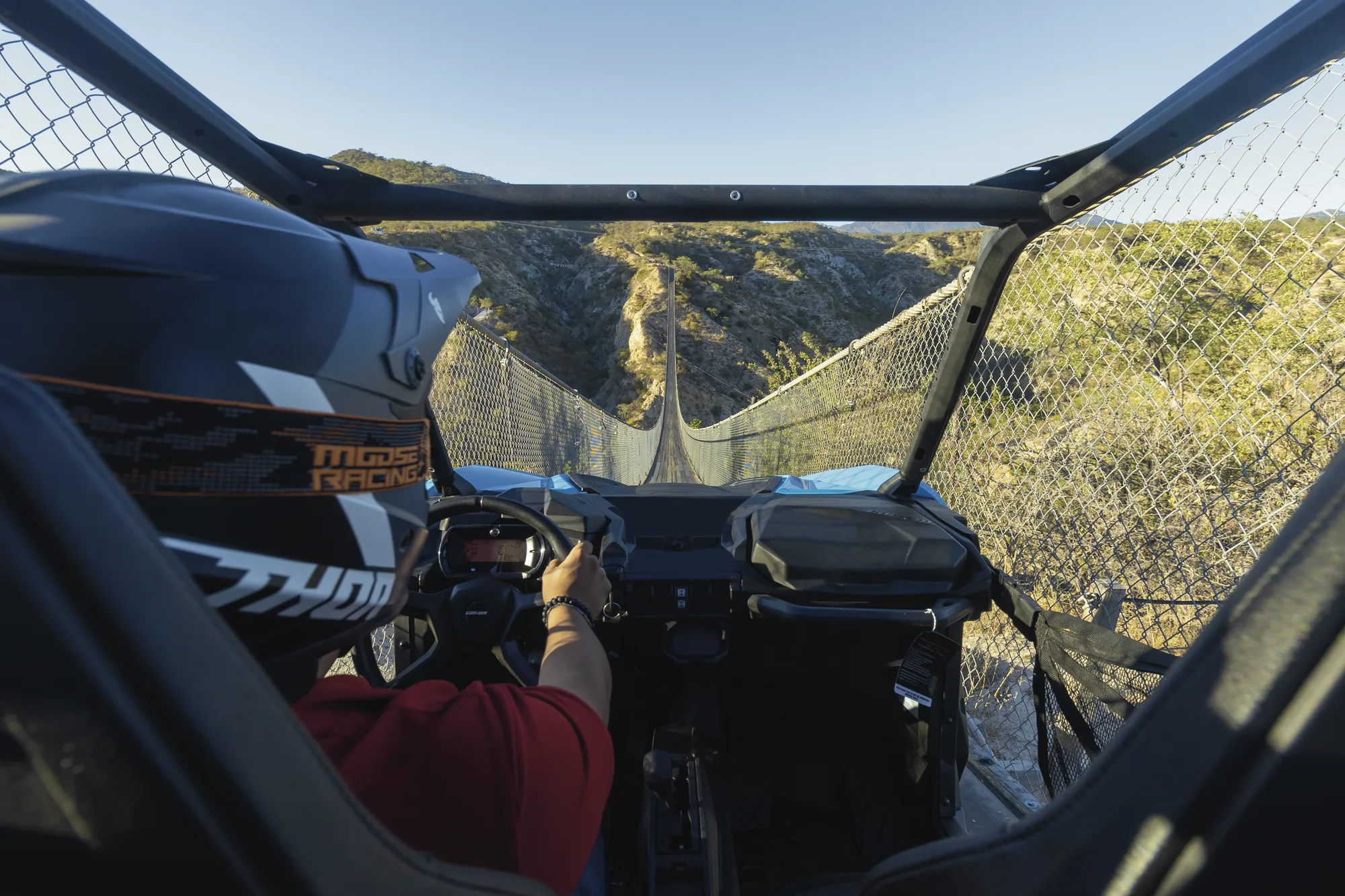 UTV con dos personas cruzando el puente colgante
